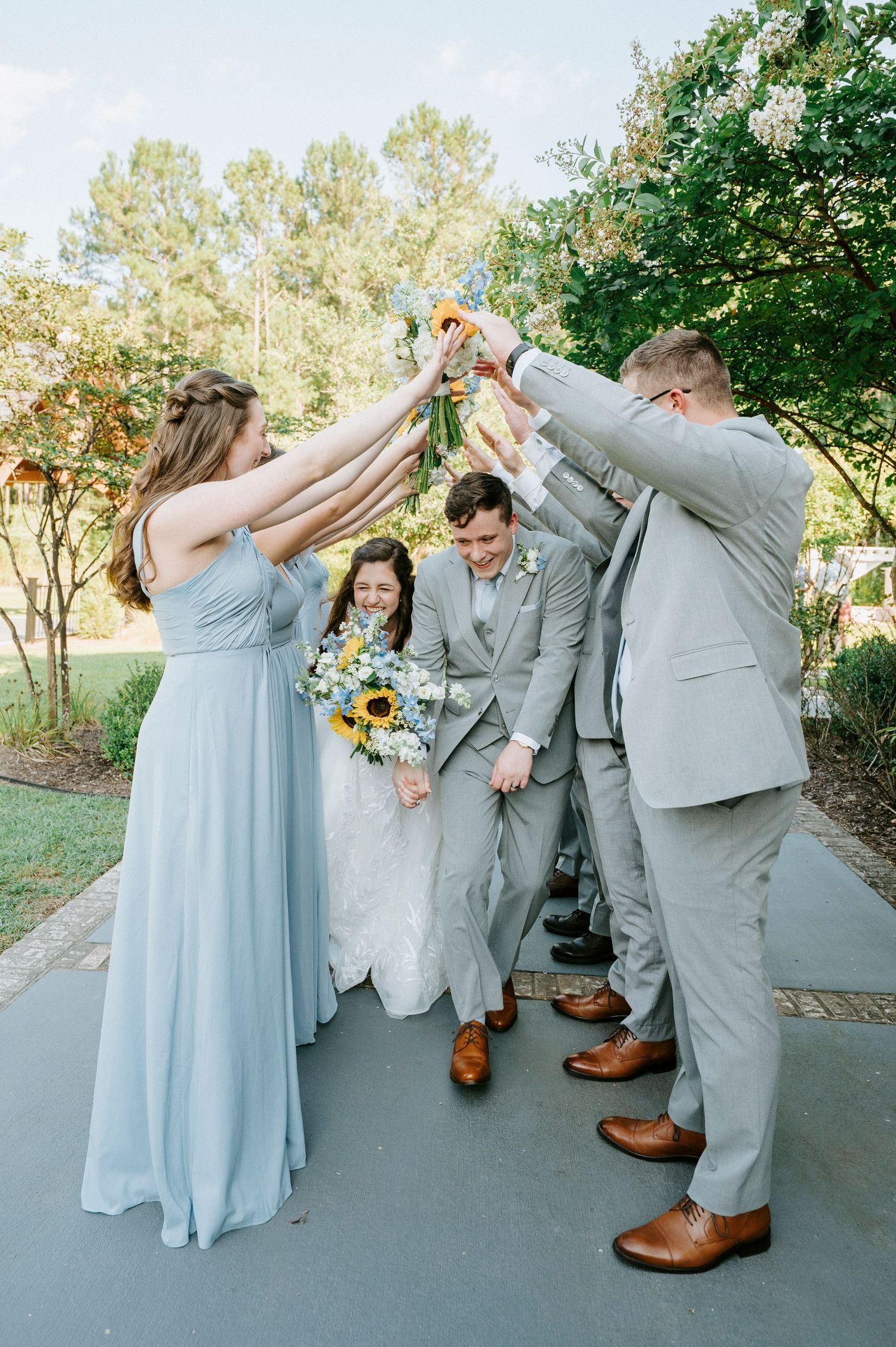 Fun wedding party photos showing playful poses in light blue dresses and gray suits.