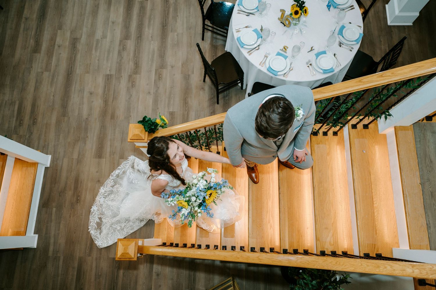 Wedding reception venue with wooden staircase illuminated by warm lighting.