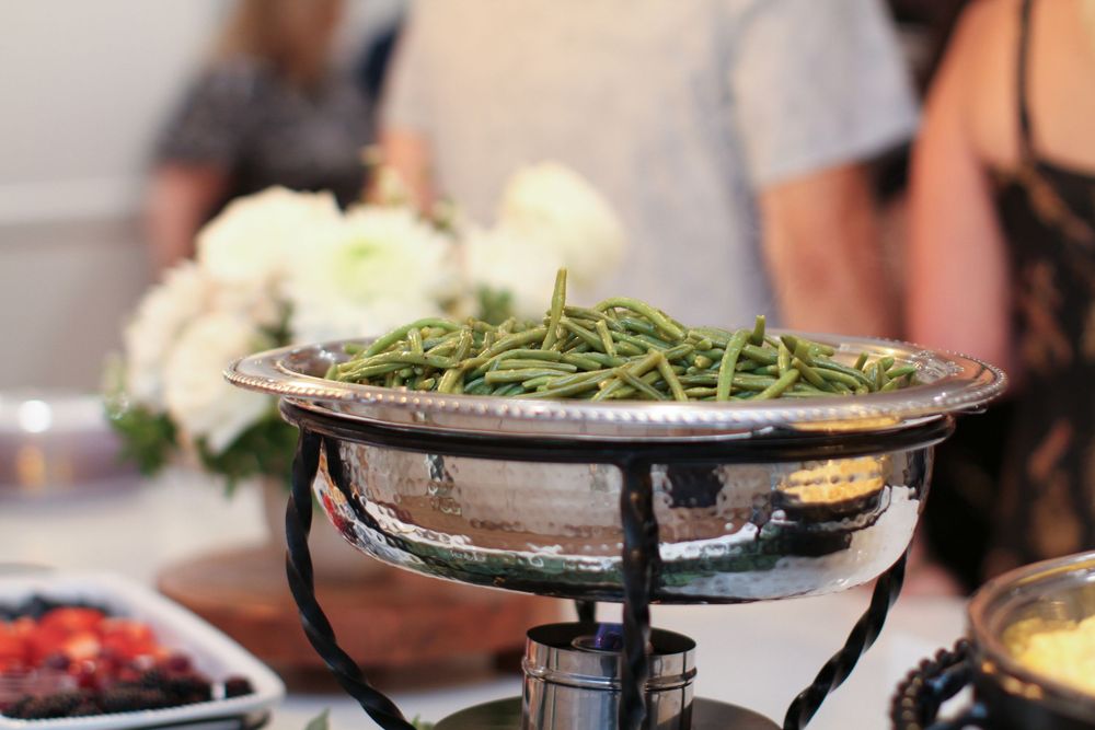 Multiple people enjoying traditional Korean BBQ with a variety of meats and side dishes on a tabletop grill.