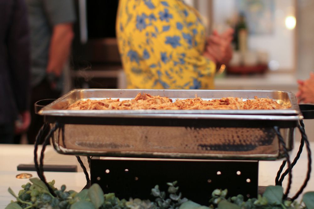 A buffet catering setup with various food dishes and serving trays displayed in metal chafing dishes.