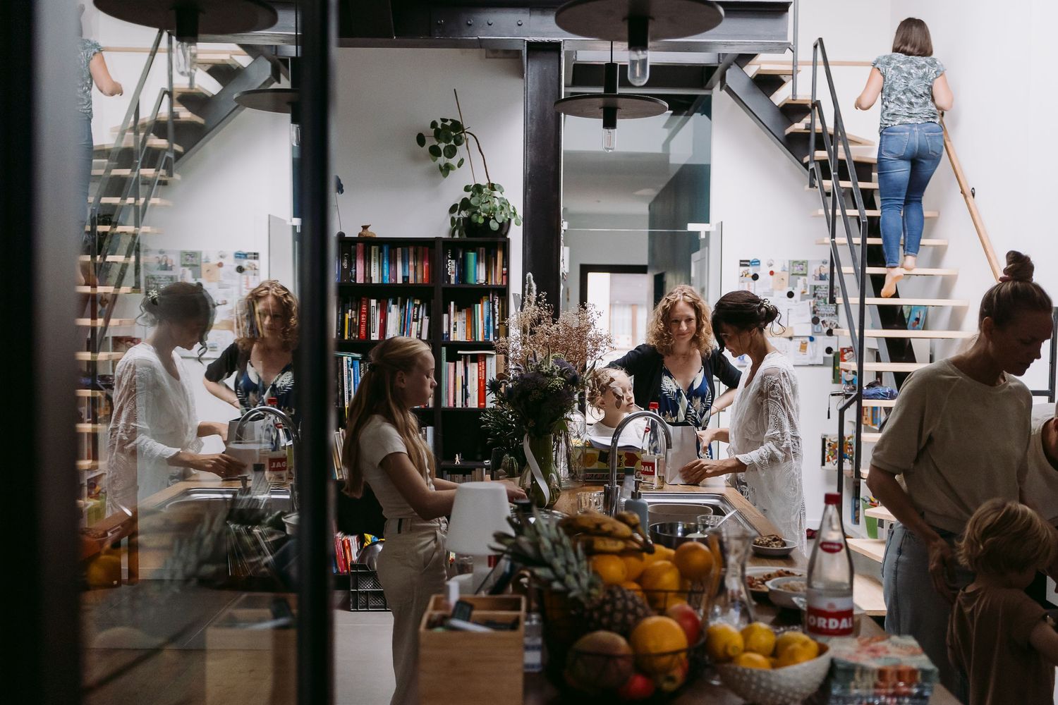 A sequence of candid moments in a bright modern kitchen showing people cooking and gathering together.