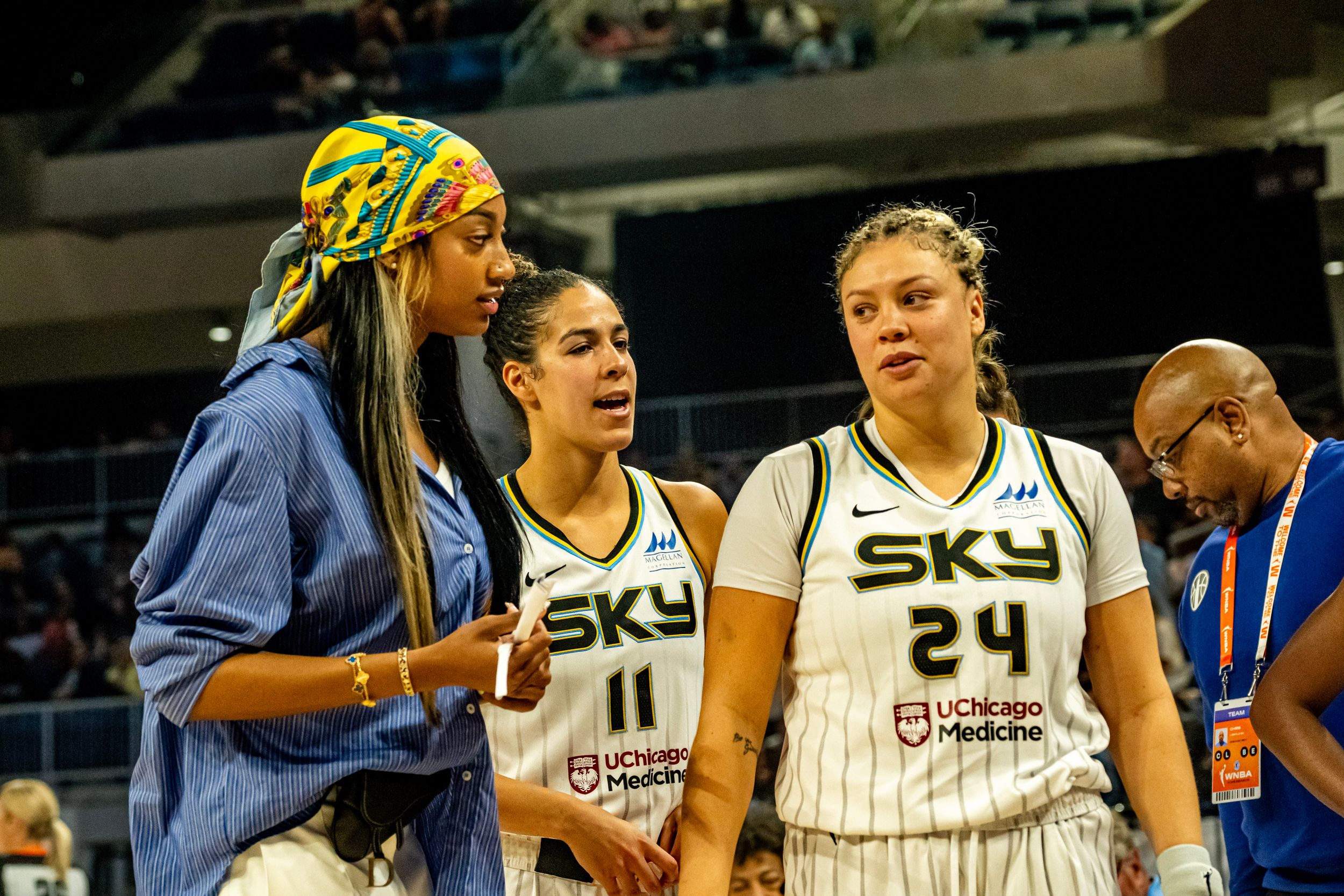 Sky basketball players interact on the sideline during a WNBA game while wearing numbered jerseys.