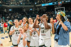Basketball players celebrate on the sidelines of a game with excitement and enthusiasm during an intense moment.