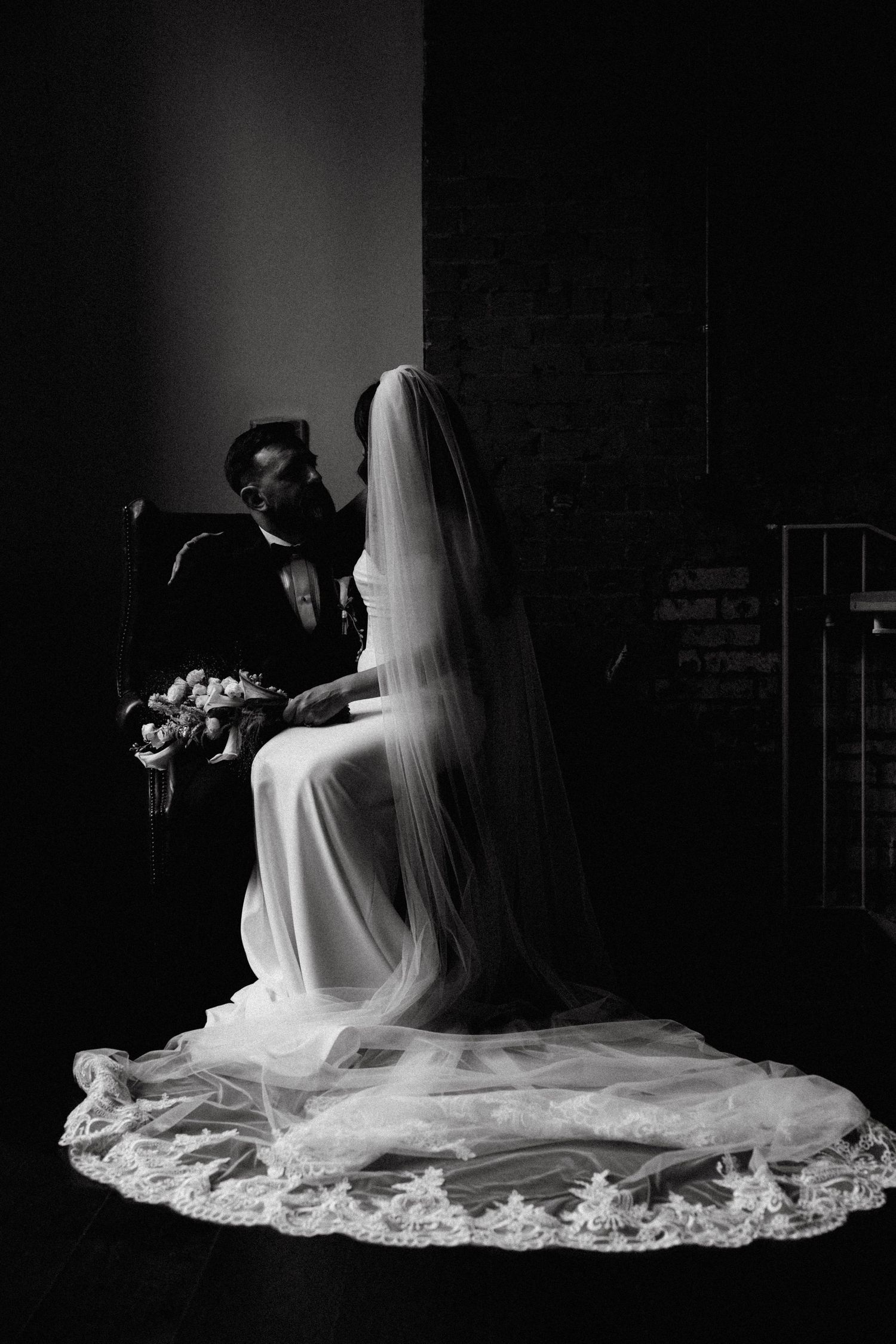 A dramatic black and white bridal portrait series showing a veiled bride sitting in moody lighting.