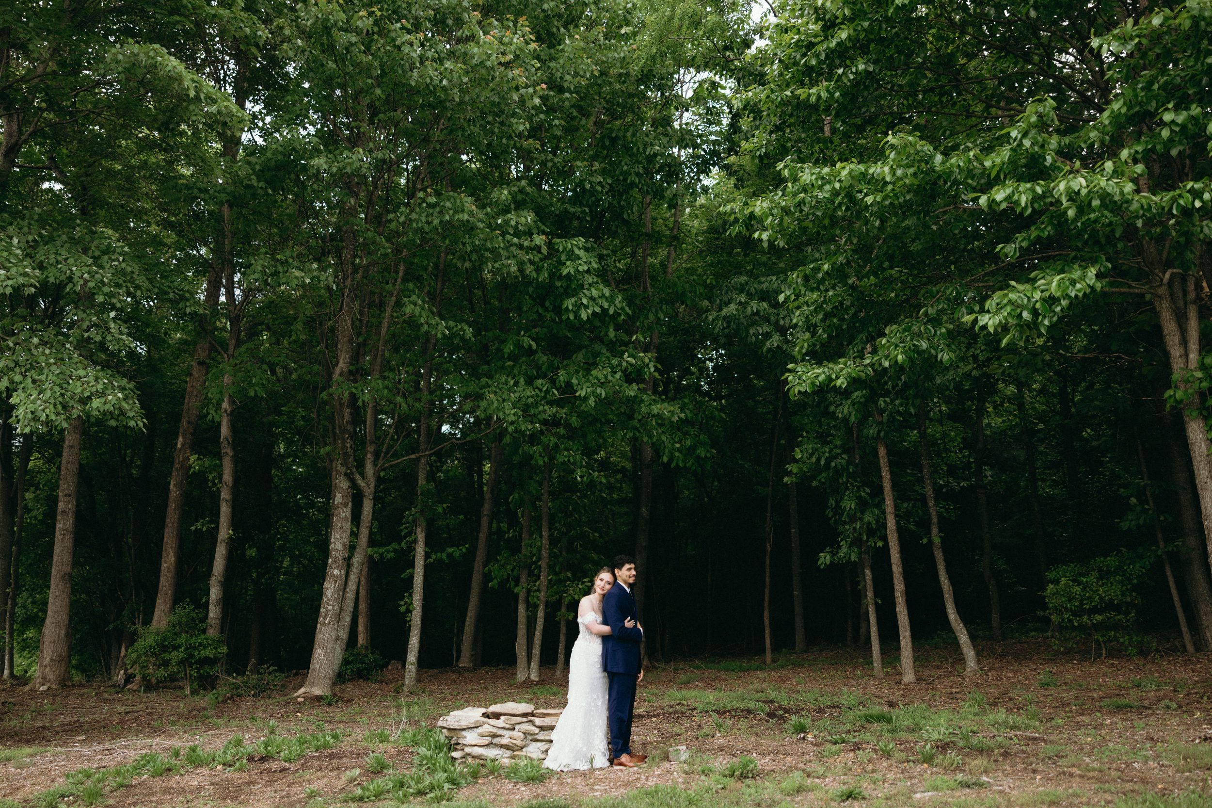 Wooded area with lush green trees creates a natural wedding ceremony backdrop. Estate and historic venue wedding photographer for NC