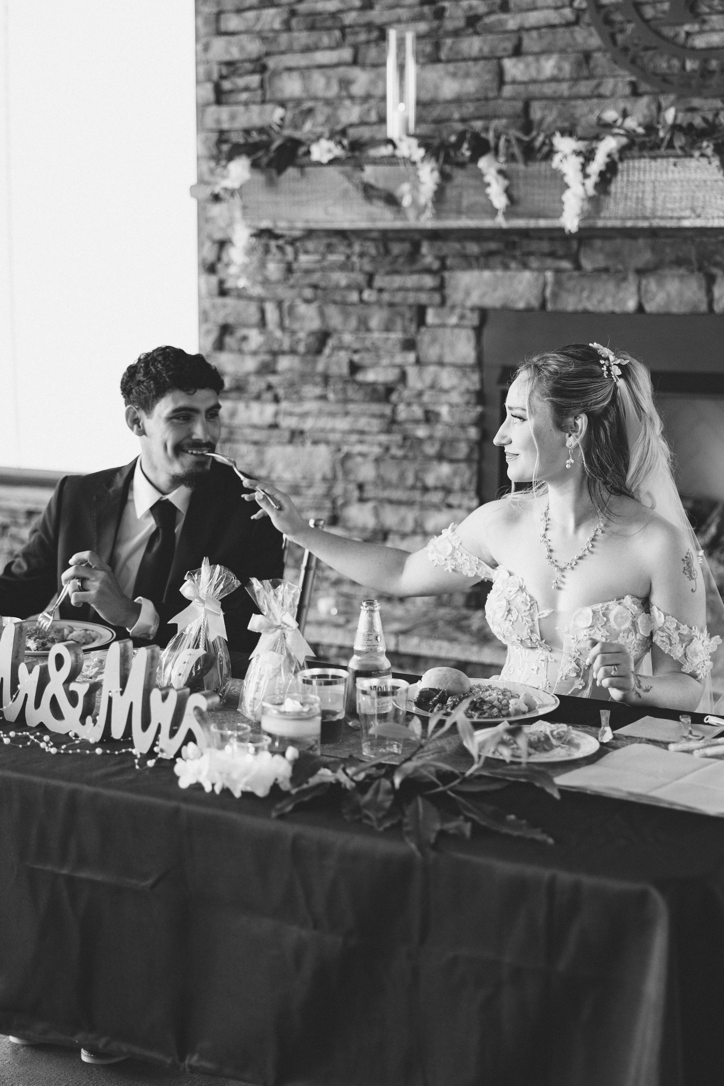 Wedding reception head table with black tablecloth and Mr & Mrs sign against stone wall. Estate and historic venue wedding photographer