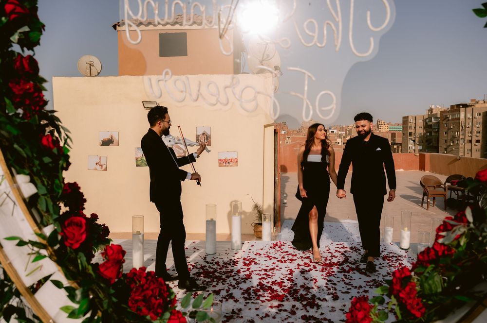 A romantic rooftop decorated with red roses, candles and floral arrangements for a special occasion.