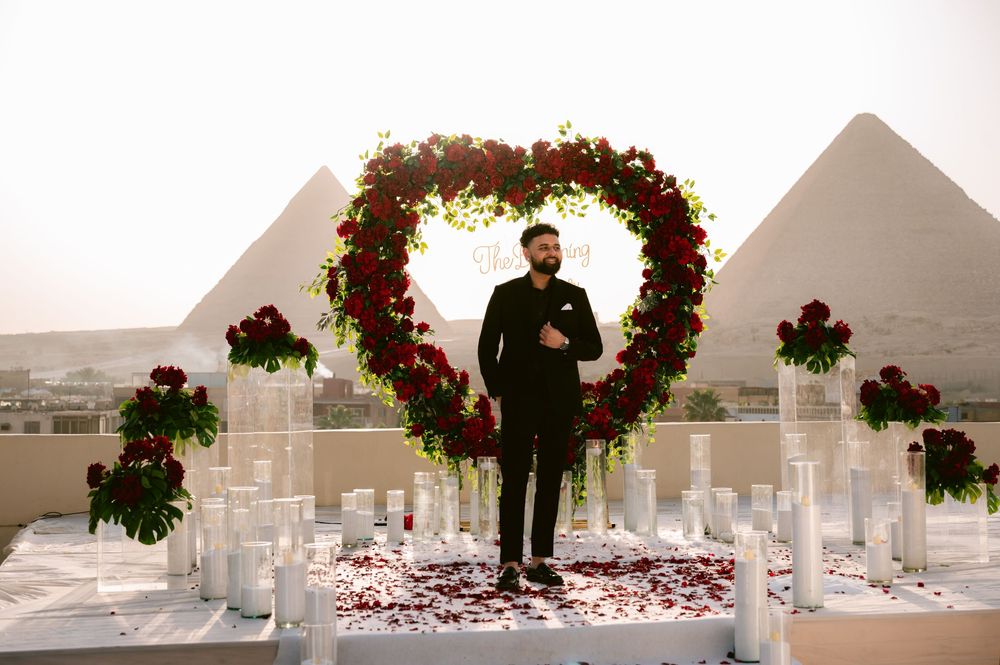 A series of wedding ceremony photos showing a floral arch with red petals scattered along a white aisle runner.