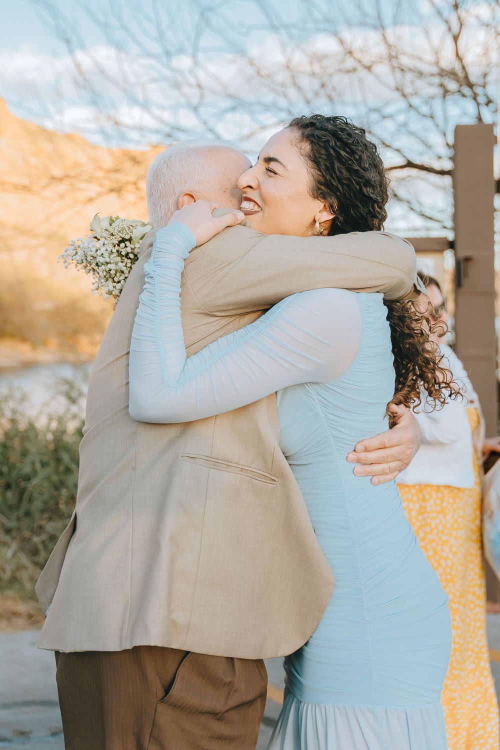 Two people share an emotional embrace during a special moment outdoors.