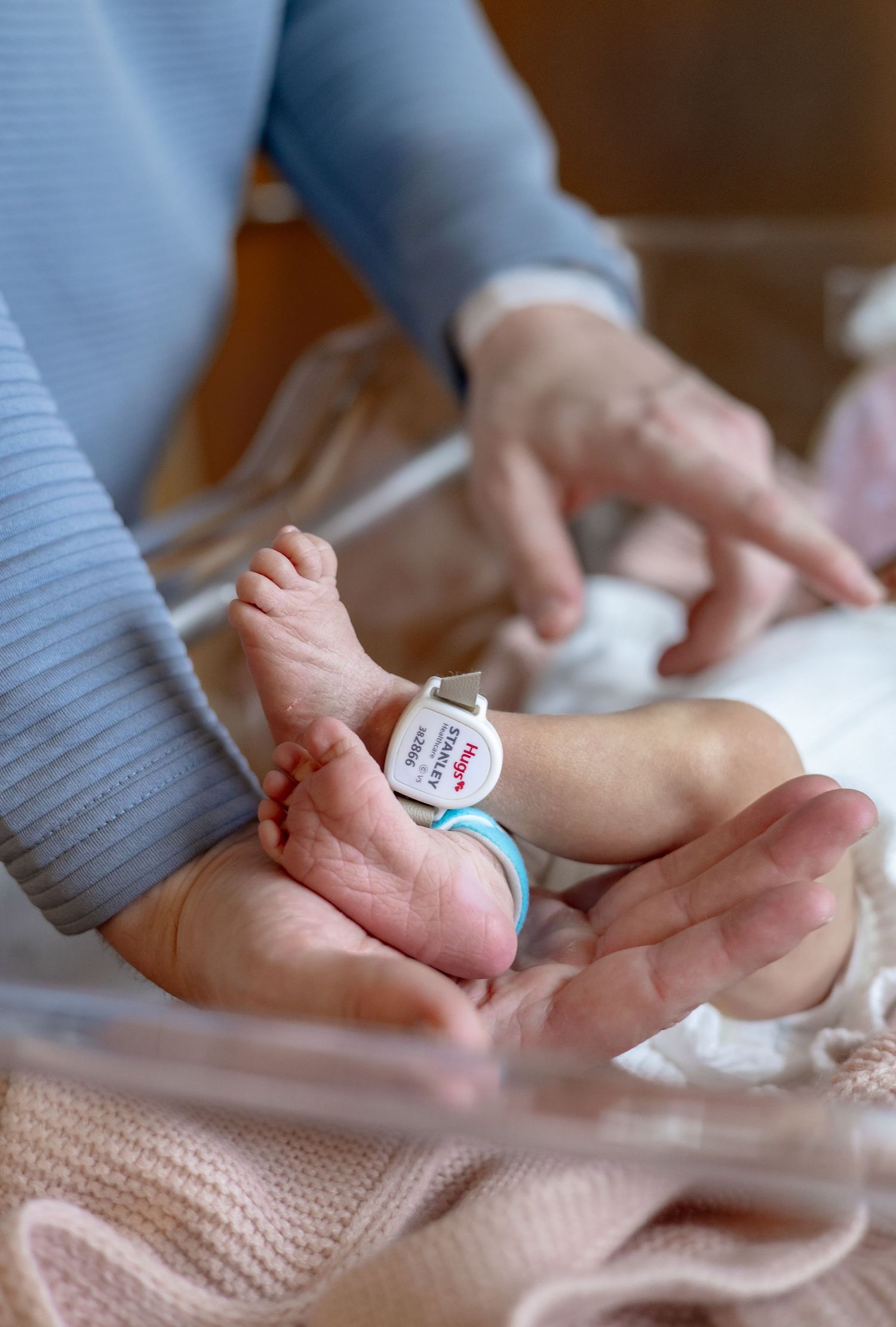 Close-up series of hands massaging a baby's foot with gentle pressure in a nurturing sequence.