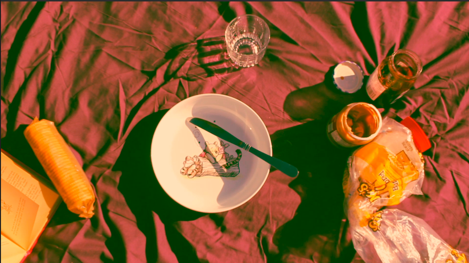 Overhead view of plates and drinks arranged on a pink surface.