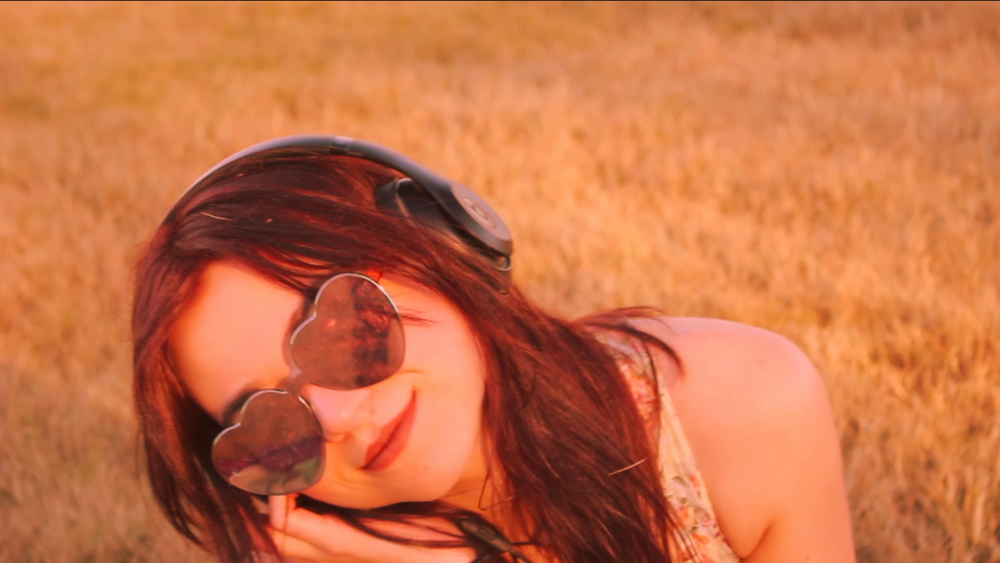 Artistic outdoor portrait in golden hour with sunglasses.