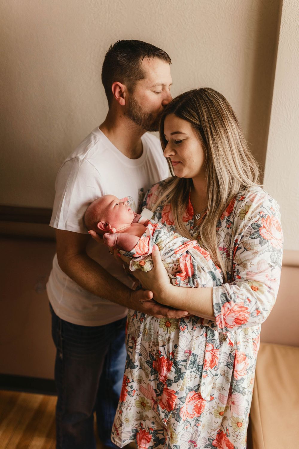 Intimate family moment with parents cradling their newborn baby.