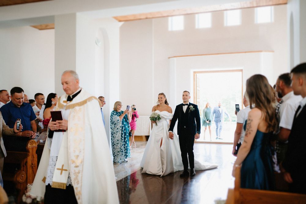 Wedding reception celebration in bright modern venue with guests mingling.