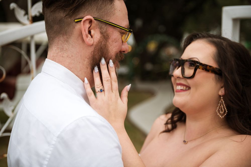 A tender moment between a couple sharing laughter and touching faces during their engagement session.