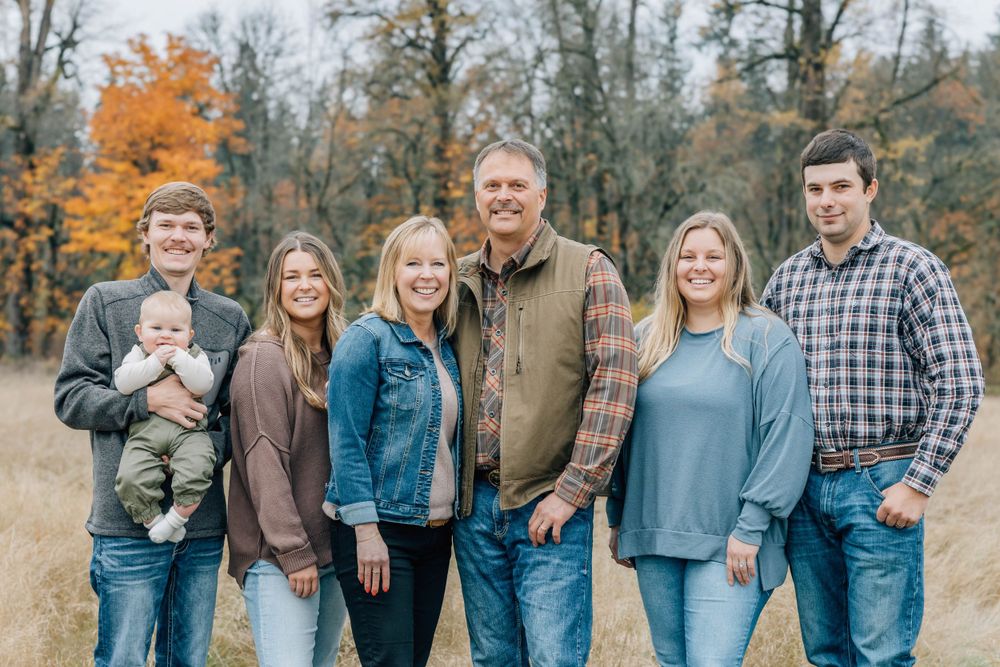 Happy family of seven posing together in a colorful fall outdoor setting.