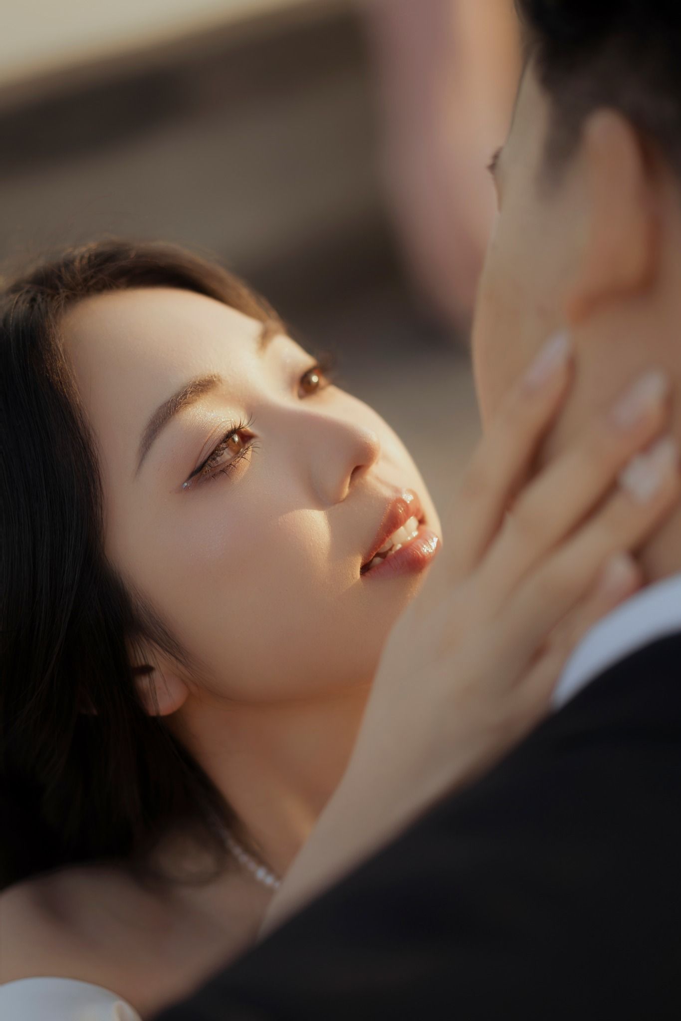 Intimate close-up portrait in dramatic lighting capturing a tender romantic moment.