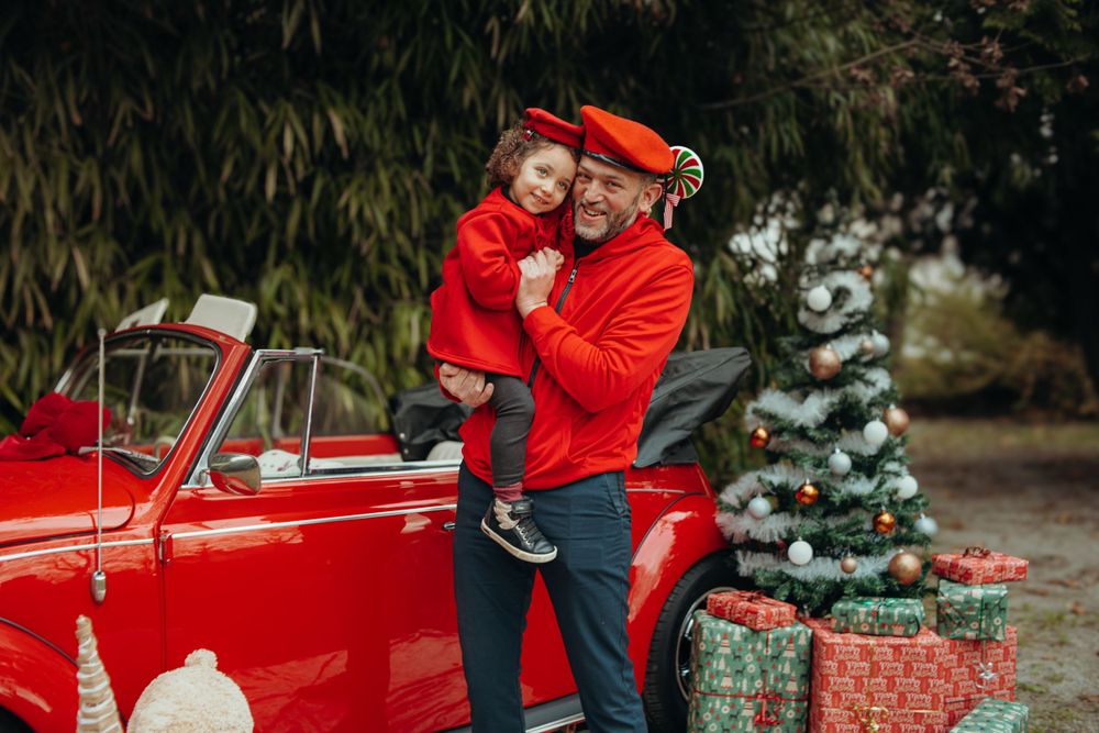 Mini-session photo de Noël 2024 avec une coccinelle VW rouge décorée pour les fêtes, créant une ambiance festive et chaleureuse.