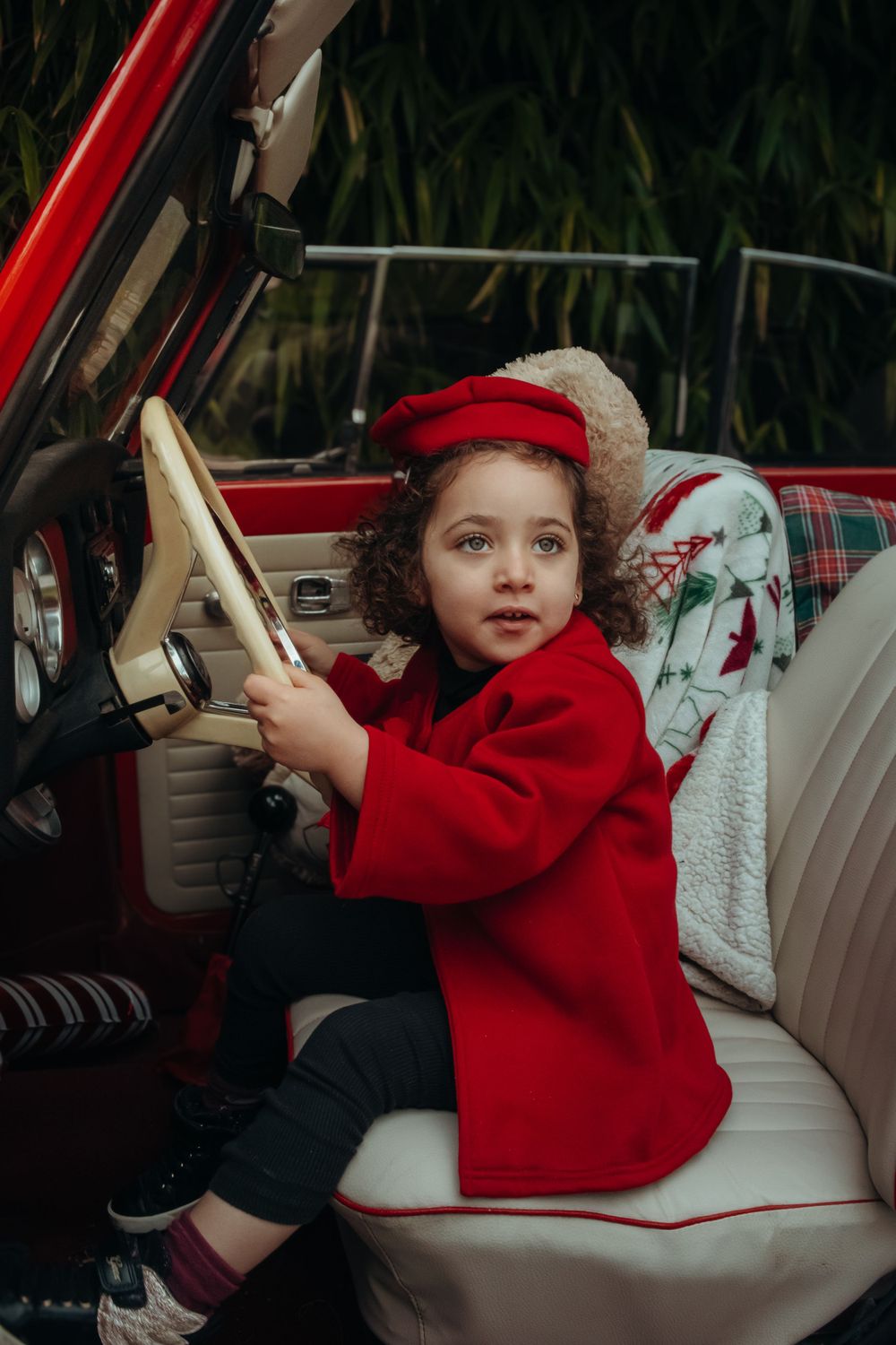 Mini-session photo de Noël 2024 avec une coccinelle VW rouge décorée pour les fêtes, créant une ambiance festive et chaleureuse.