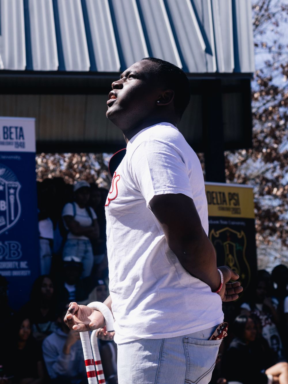People in white t-shirts performing at an outdoor gathering.