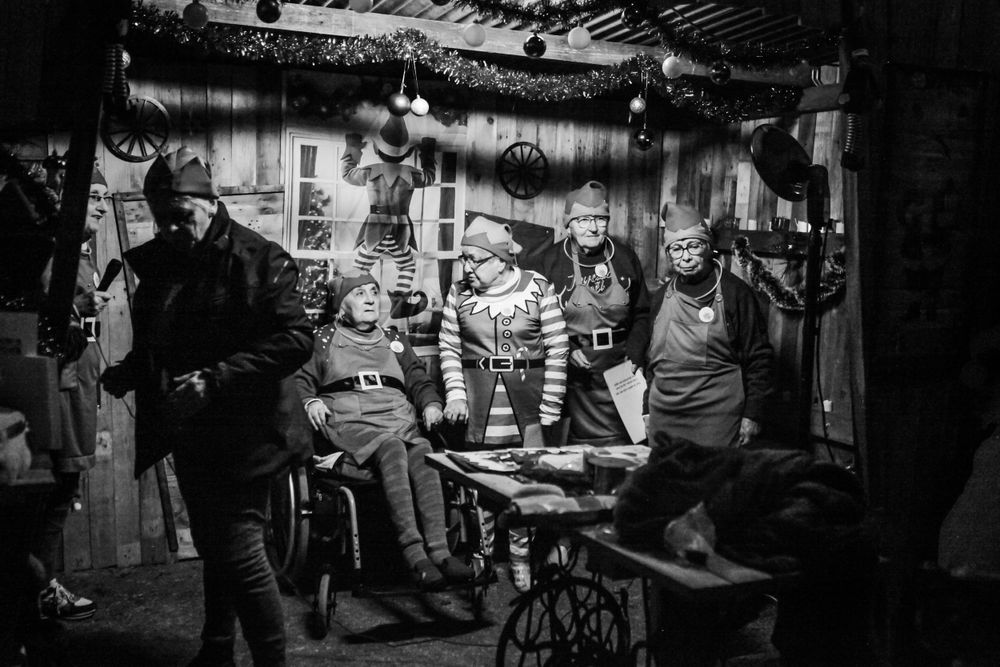 Black and white panoramic view of a busy indoor marketplace or gathering.