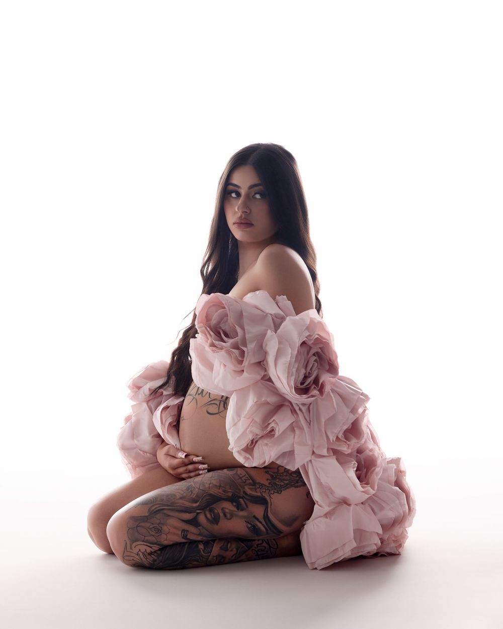 A person in a pink ruffled dress poses gracefully against a white backdrop in three artistic portraits.