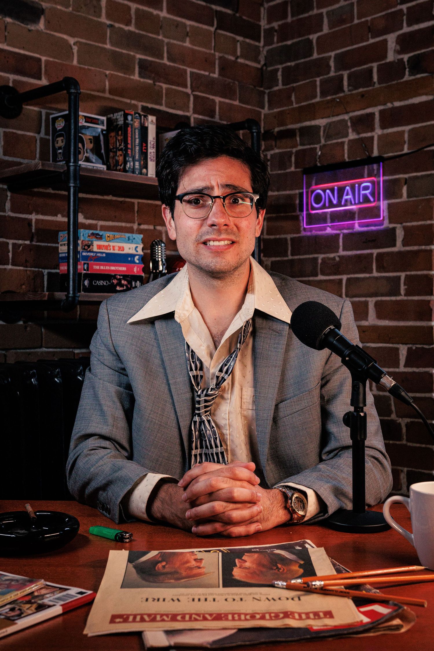 Photograph of person sitting at a desk with a brick wall in the background