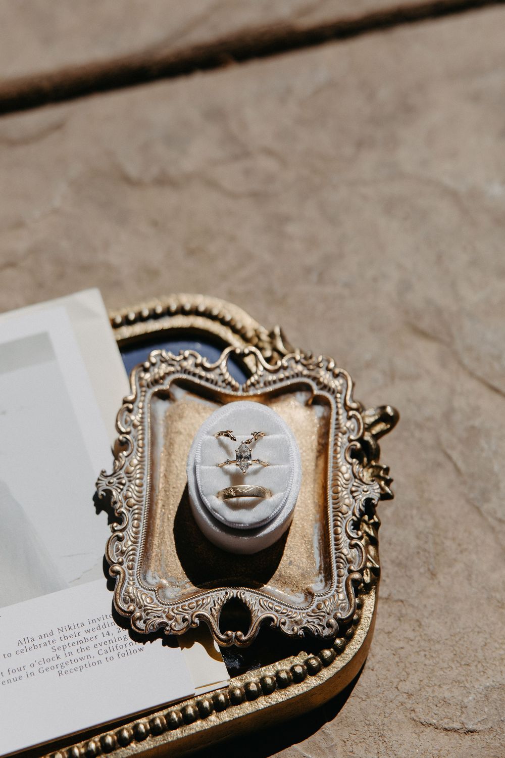 A vintage-style ornate frame holding a decorative face sculpture, photographed in dramatic lighting.
