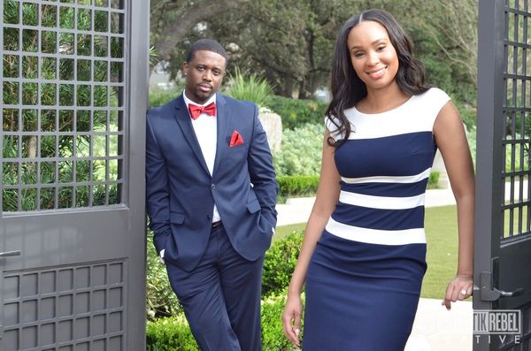 Wedding party members in navy blue and white formal attire pose together in an outdoor garden setting.