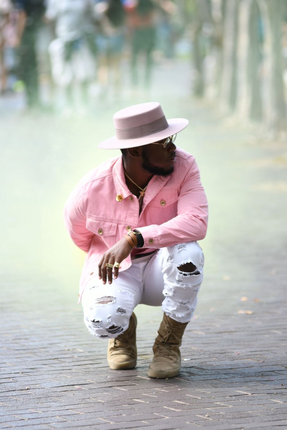 Street style photo with pink jacket, white distressed jeans and fedora hat.