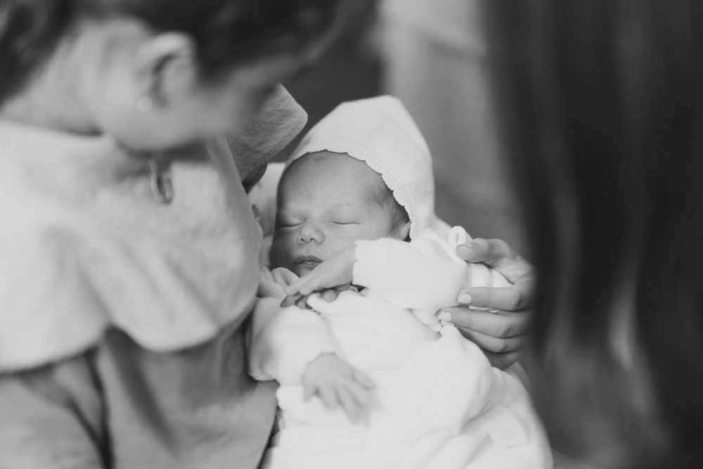 Black and white photo of a newborn baby being cradled.