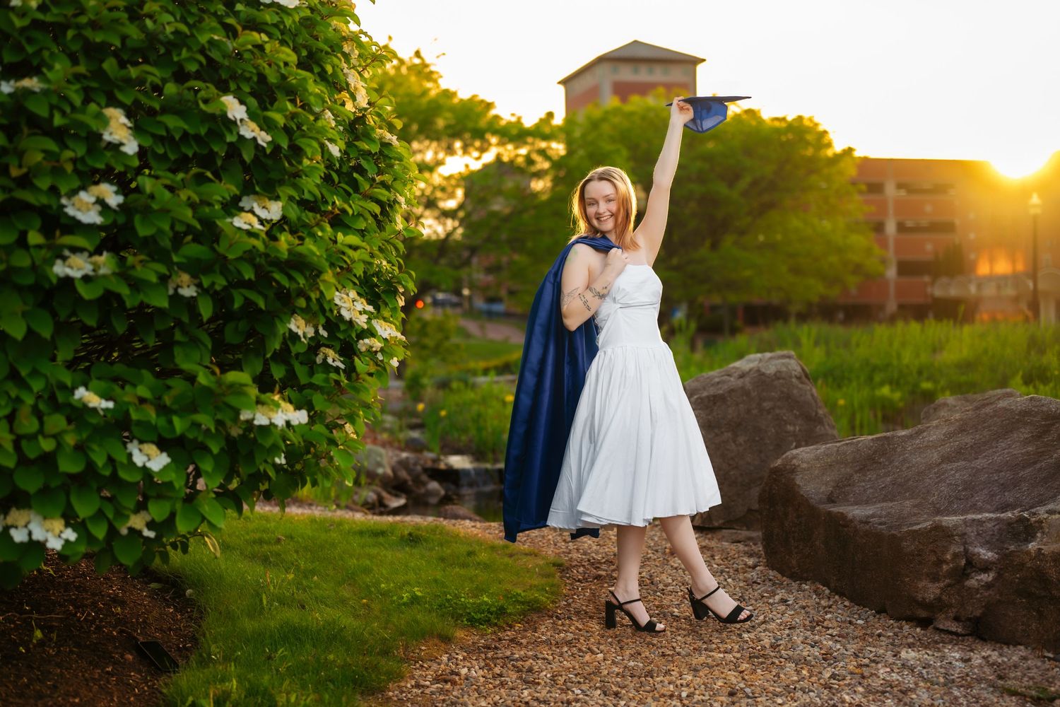 A series of sunset graduation photos taken on a landscaped campus path.