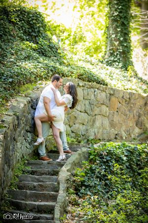 Romantic couple sharing an intimate moment on stone steps surrounded by ivy.
