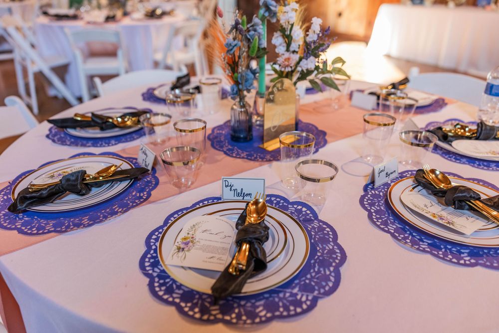 Elegant table settings with blue charger plates and gold accents at wedding reception.