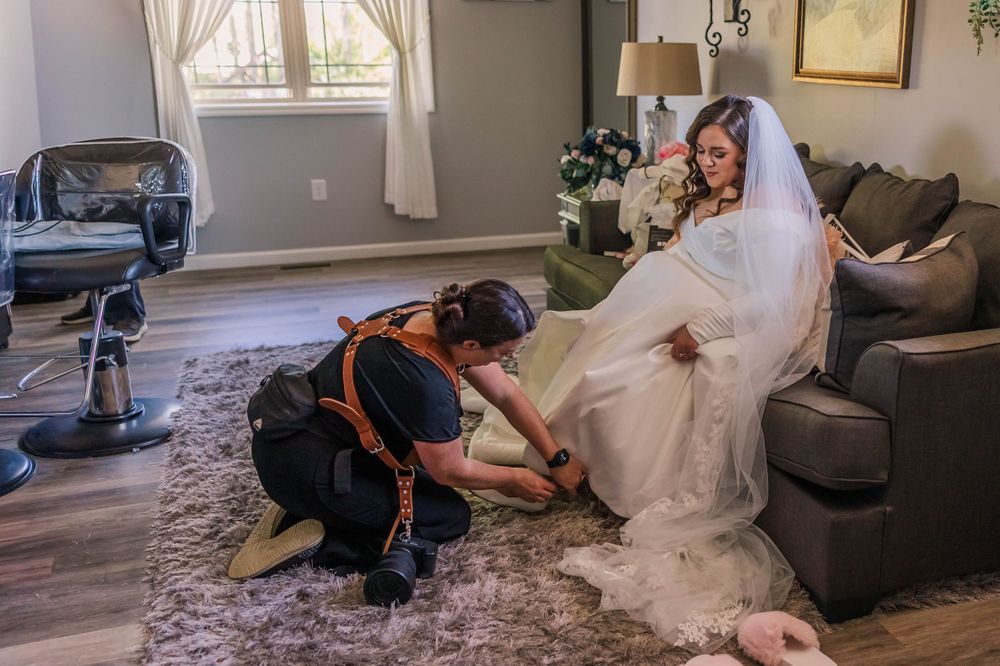 Wedding dress fitting and adjustments being made in living room setting.