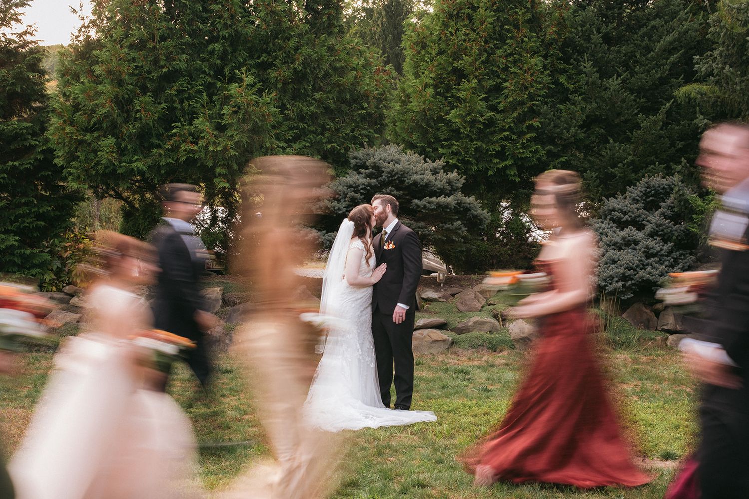 People dancing together at an indoor reception with warm lighting and a festive party atmosphere in the background.