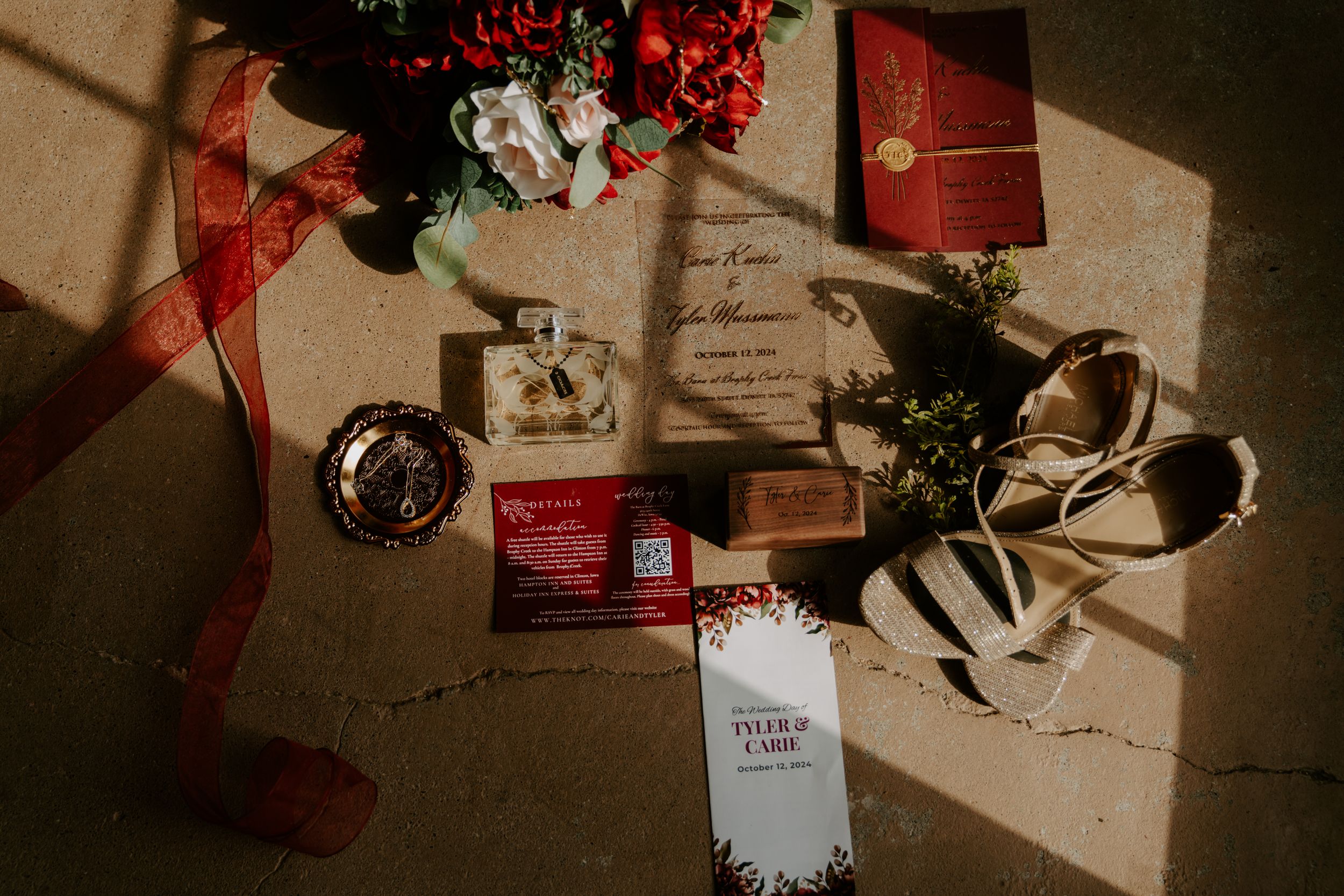 Holiday gifts and decorations with red berries arranged on a rustic surface.