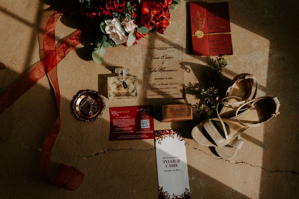 Holiday gifts and decorations with red berries arranged on a rustic surface.