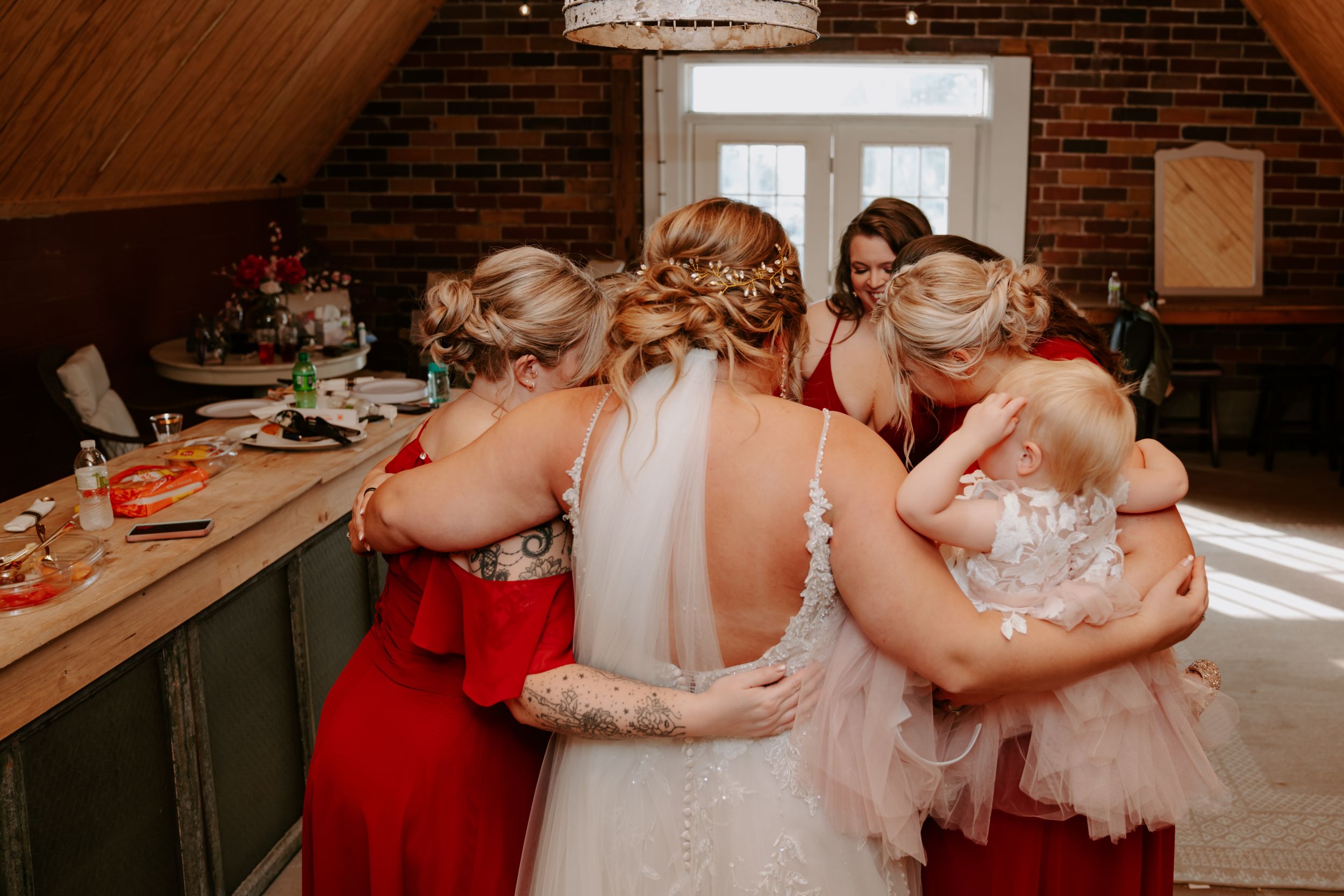 Wedding party members in red dresses preparing for the celebration.