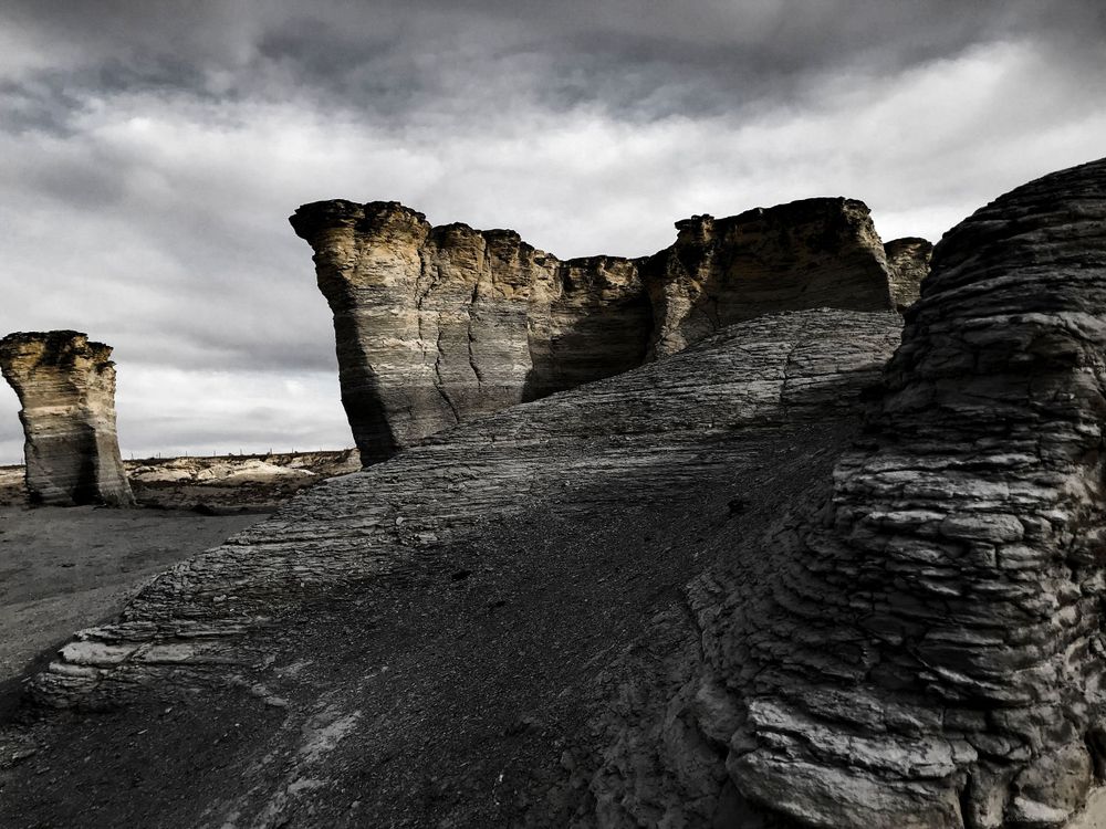 Sweeping view of eroded limestone formations under dramatic overcast skies.