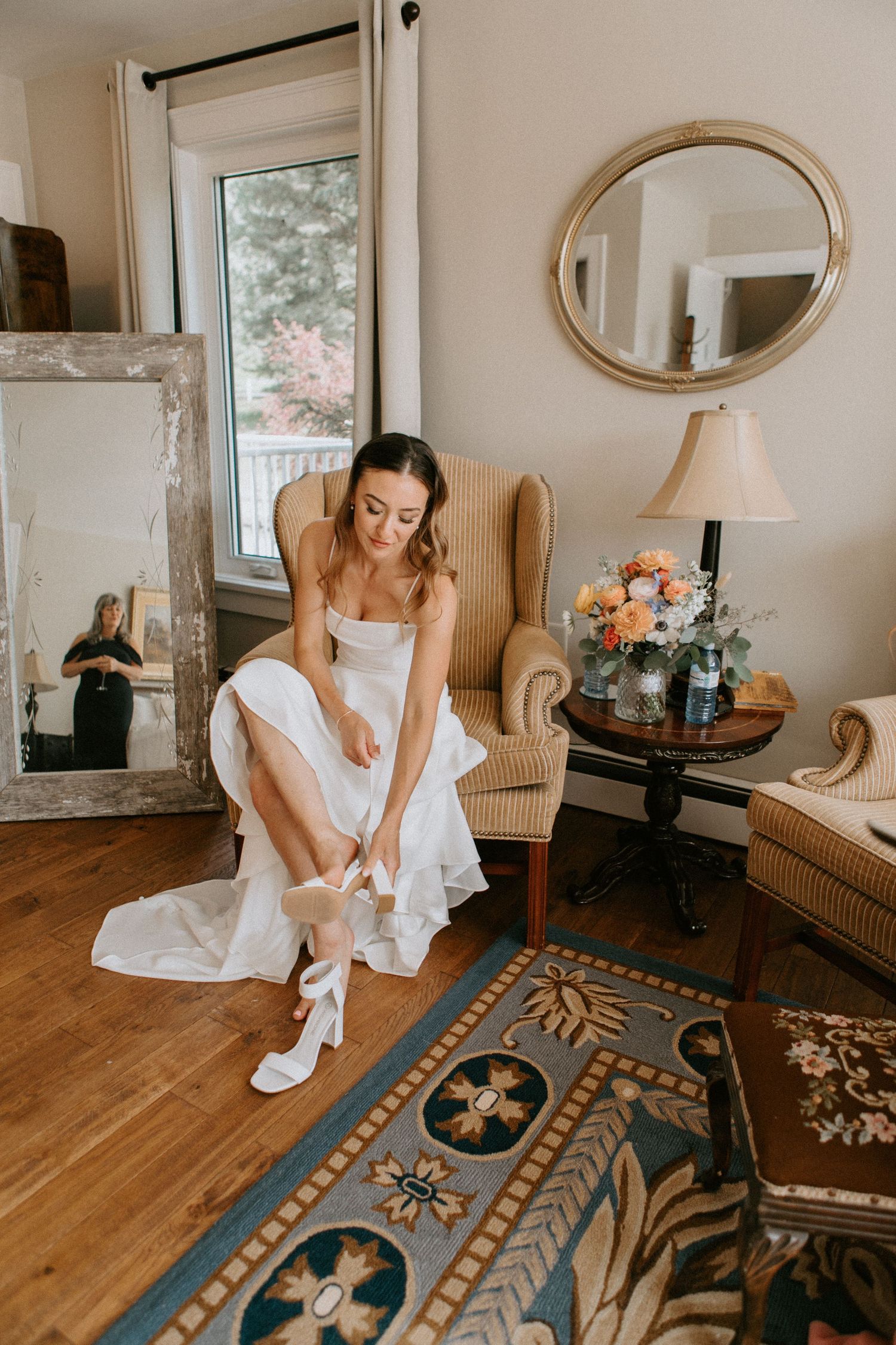 Getting ready scene in elegant room with armchair and patterned rug.