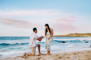 Maui Hawaii for beach destination wedding in maui hawaii. A romantic beach proposal scene with waves crashing in the background at sunset.
