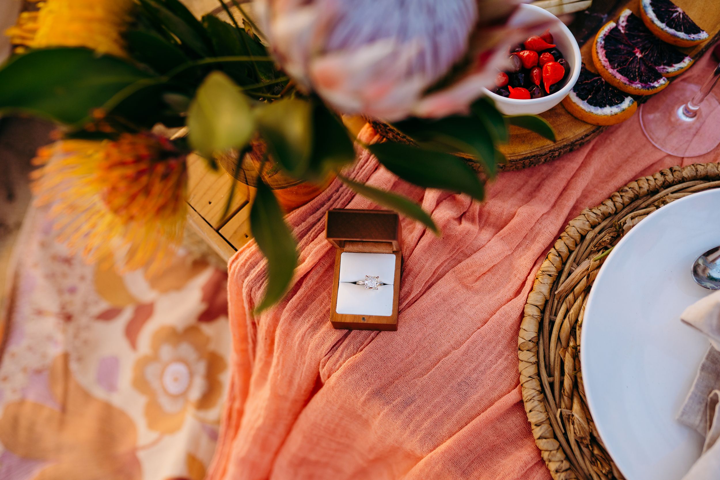 Elegant table settings with floral arrangements and pink decor at an outdoor celebration.