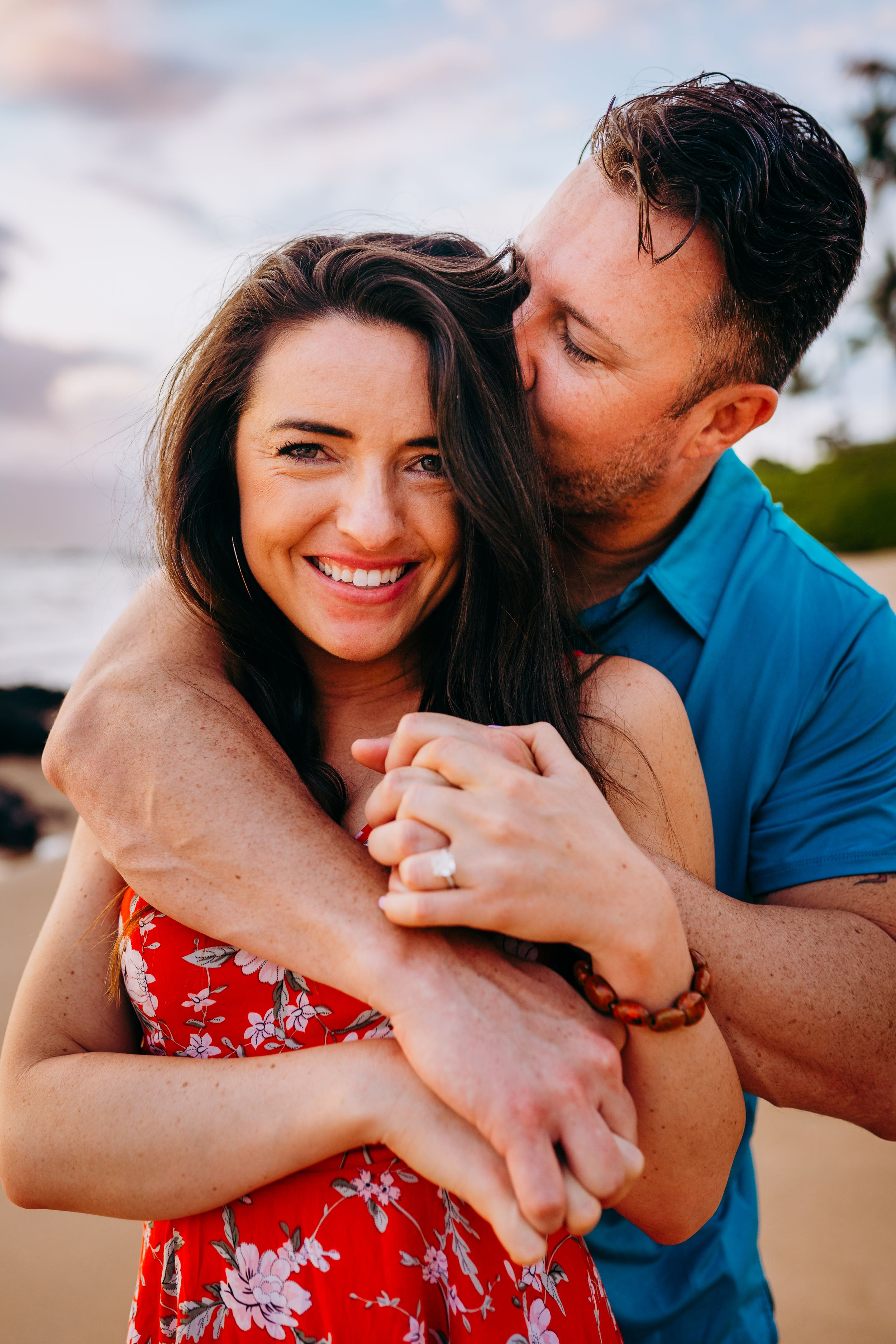 A couple shares an intimate moment together on a beach during sunset in kaanapali maui for couples photography session sunrise family