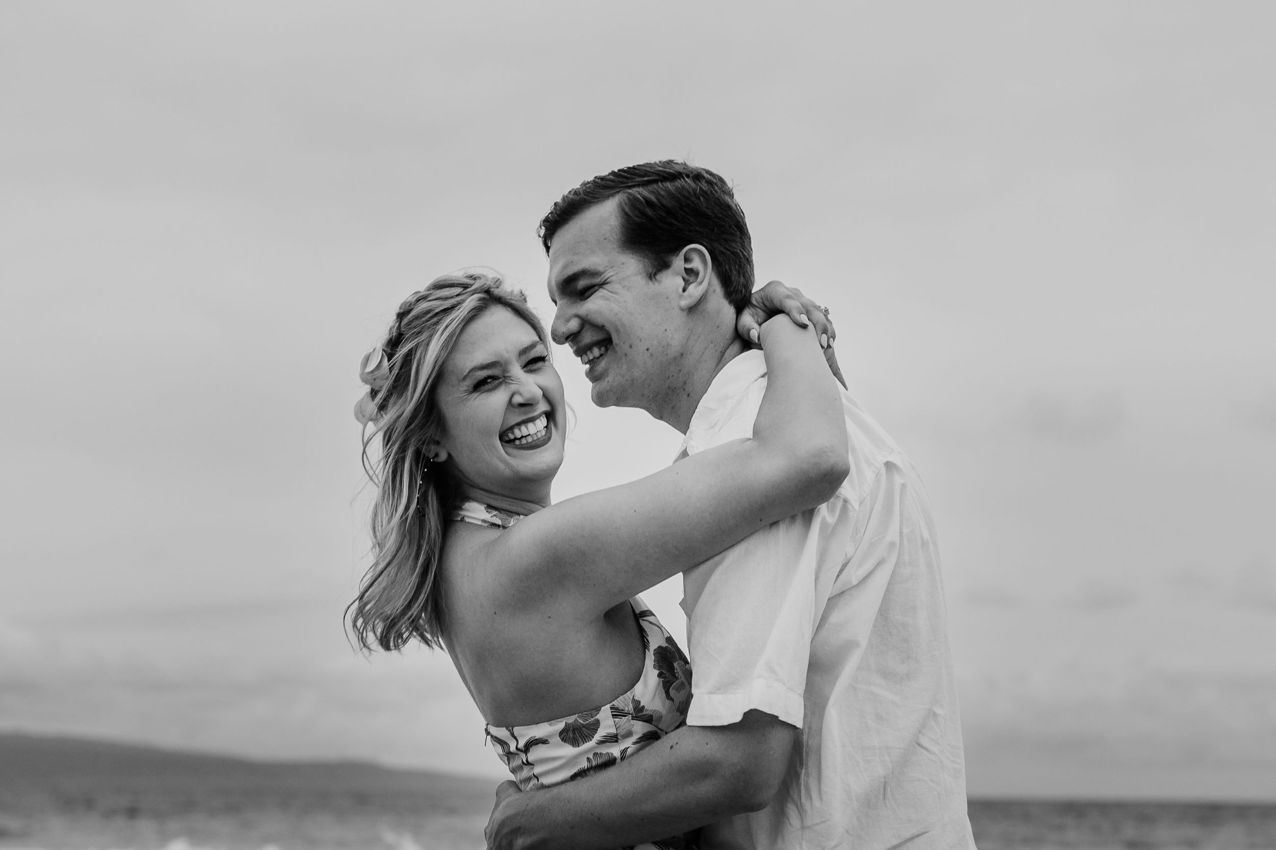 South Maui couples photography at sunset. A joyful couple shares a romantic moment together in black and white photography.
