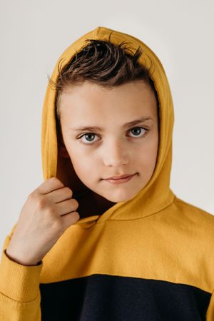 Close-up portrait in yellow and black color block hoodie.