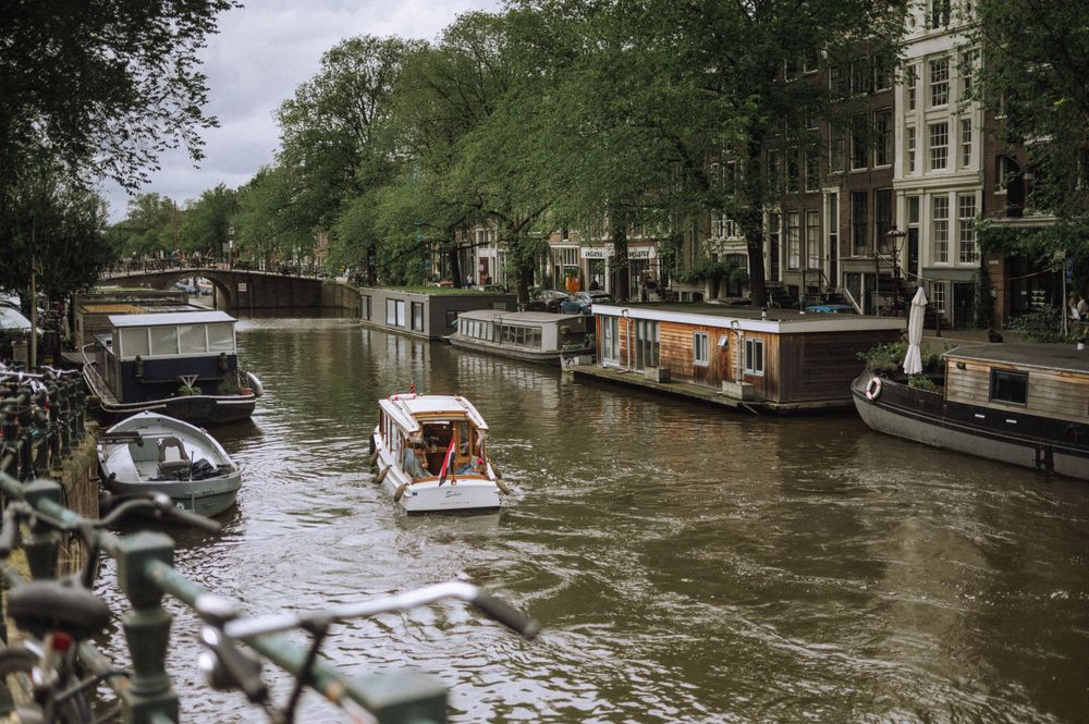 Canal view of Amsterdam with historic buildings and boats along the waterway.