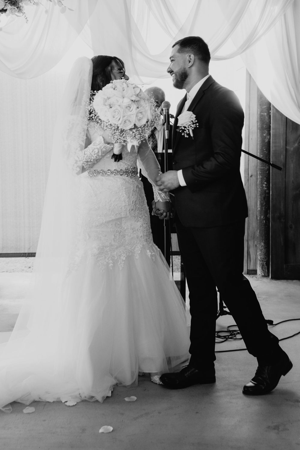 A romantic wedding moment captured in black and white as a couple shares a tender dance in their formal attire.