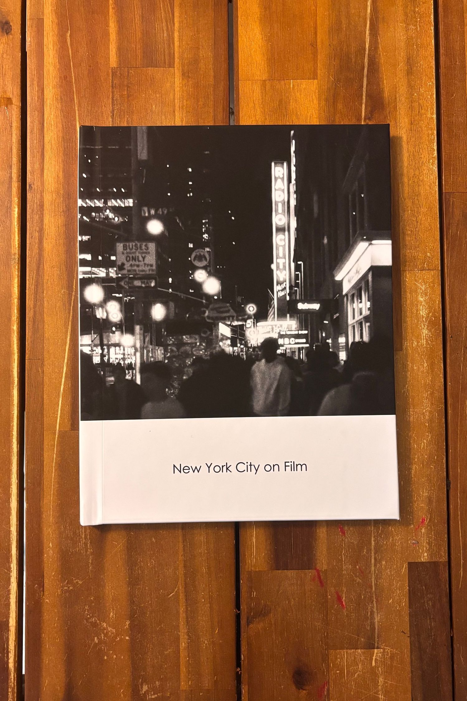 Black and white photo book titled 'New York City on Film' showing illuminated city streets at night.
