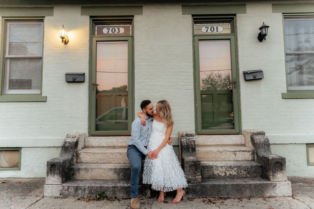 A tender moment shared on historic building steps with white doors and brick details.